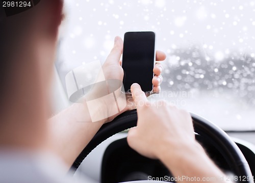 Image of close up of man using smartphone while driving car