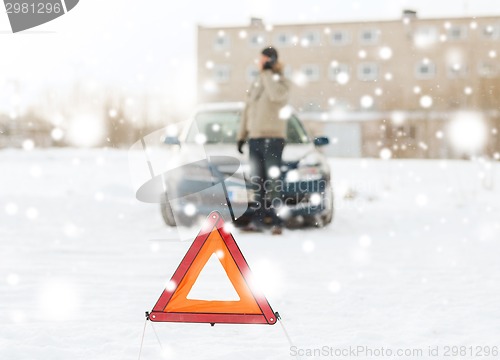 Image of closeup of man with broken car and smartphone