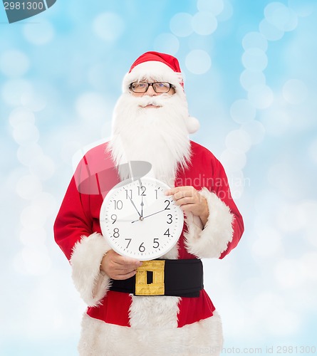 Image of man in costume of santa claus with clock