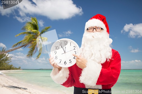 Image of man in costume of santa claus with clock