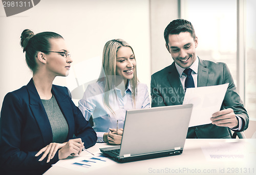Image of business team with laptop having discussion
