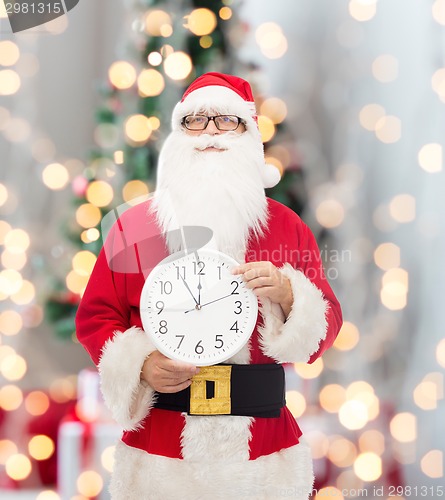 Image of man in costume of santa claus with clock