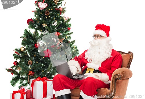 Image of man in costume of santa claus with laptop