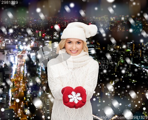 Image of smiling woman in winter clothes with snowflake