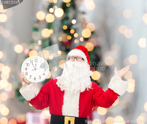 Image of man in costume of santa claus with clock