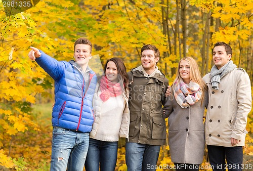 Image of group of smiling men and women in autumn park