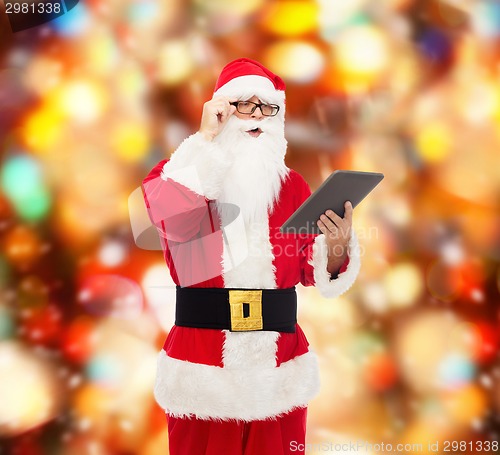 Image of man in costume of santa claus with tablet pc