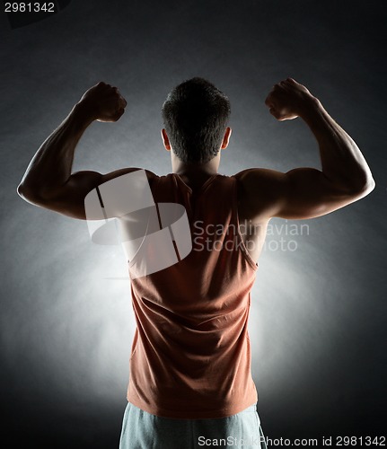 Image of young man showing biceps