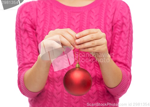 Image of close up of woman in sweater with christmas ball