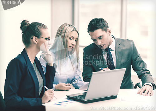Image of business team with laptop having discussion