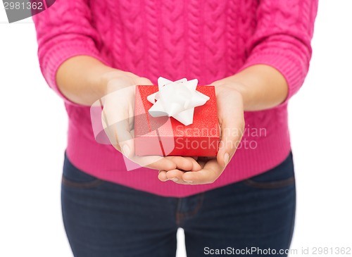 Image of close up of woman in pink sweater holding gift box