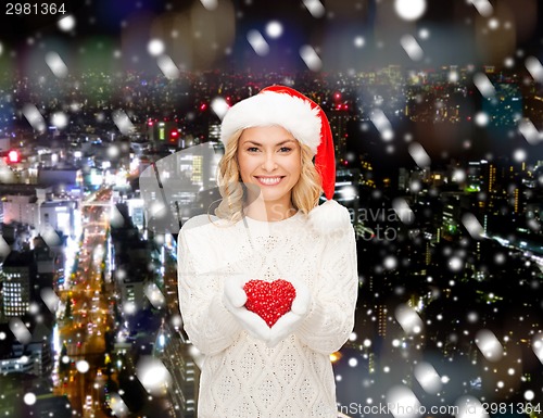 Image of smiling woman in santa helper hat with red heart