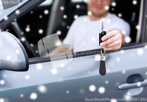 Image of close up of smiling man with car key outdoors