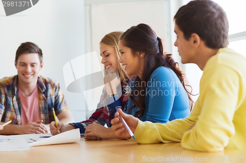 Image of group of smiling students with blueprint