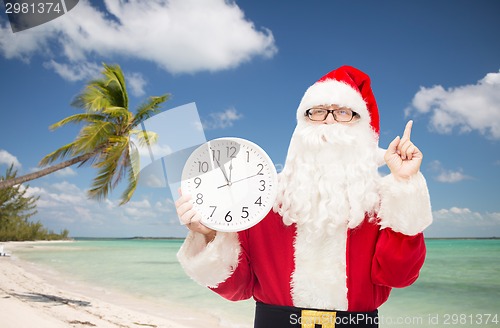 Image of man in costume of santa claus with clock