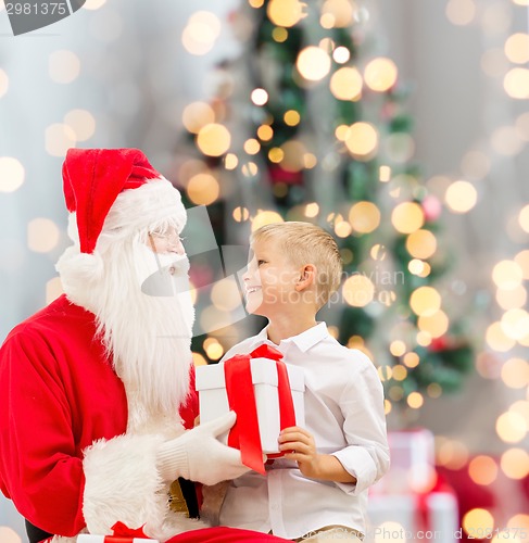 Image of smiling little boy with santa claus and gifts
