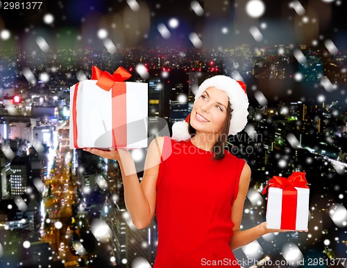 Image of smiling woman in red dress with gift box