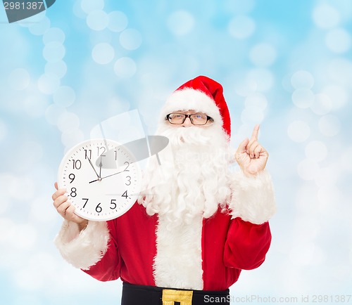 Image of man in costume of santa claus with clock