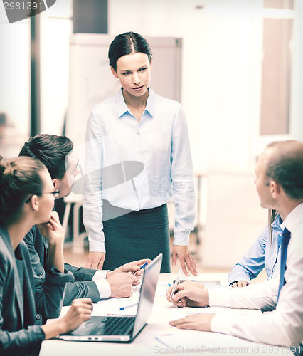 Image of strict female boss talking to business team