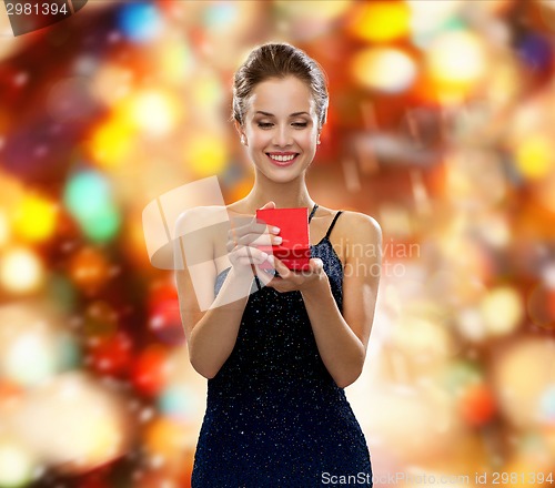 Image of smiling woman holding red gift box