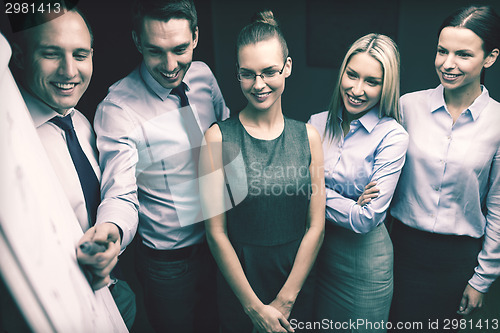 Image of business team with flip board having discussion