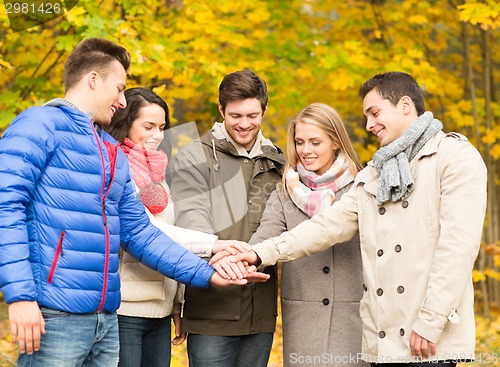 Image of group of smiling men and women in autumn park