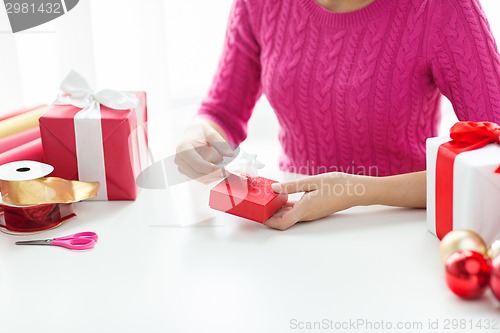 Image of close up of woman decorating christmas presents