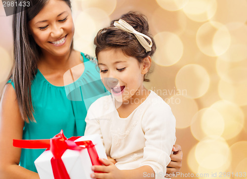 Image of happy mother and little girl with gift box