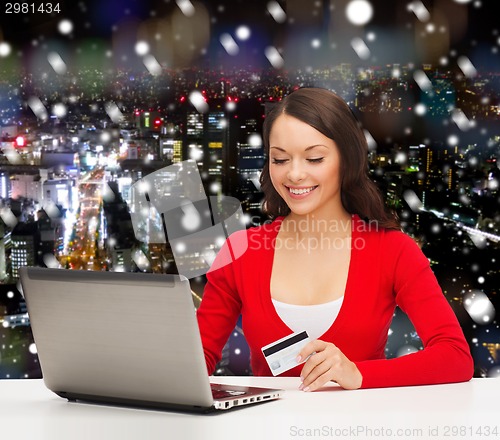 Image of smiling woman with credit card and laptop