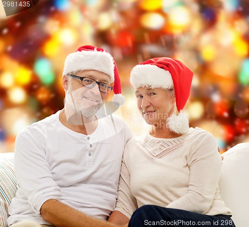 Image of happy senior couple in santa helper hats