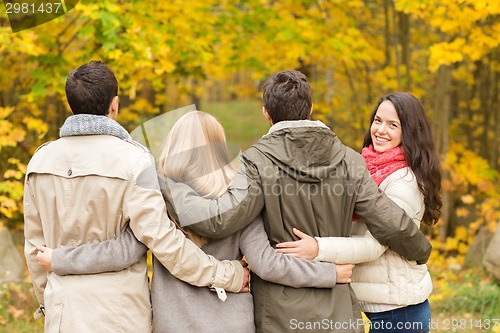 Image of group of smiling men and women in autumn park