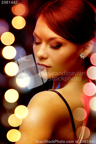 Image of woman in evening dress wearing diamond earrings