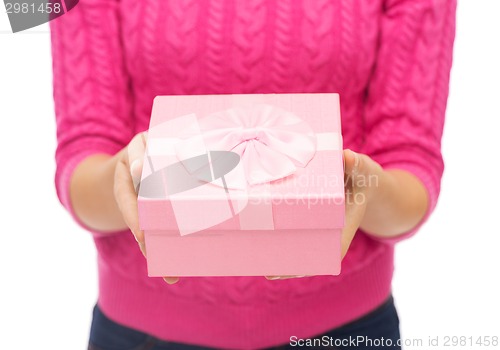 Image of close up of woman in pink sweater holding gift box