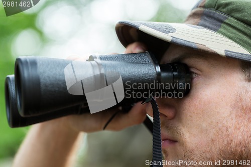 Image of close up of soldier or hunter with binocular