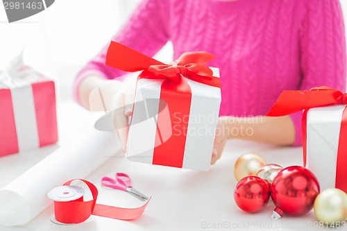 Image of close up of woman decorating christmas presents