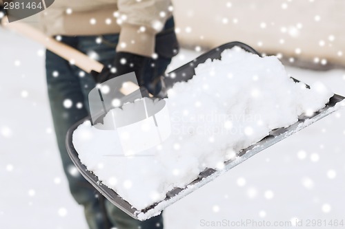 Image of closeup of man digging snow with shovel