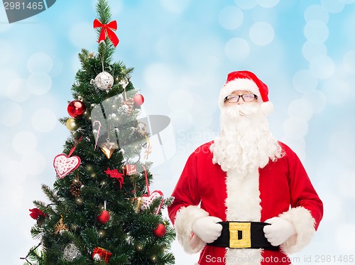 Image of man in costume of santa claus with christmas tree