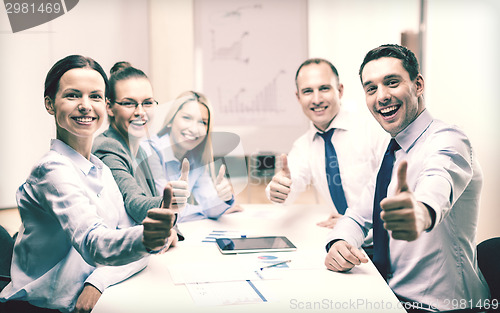 Image of business team showing thumbs up in office