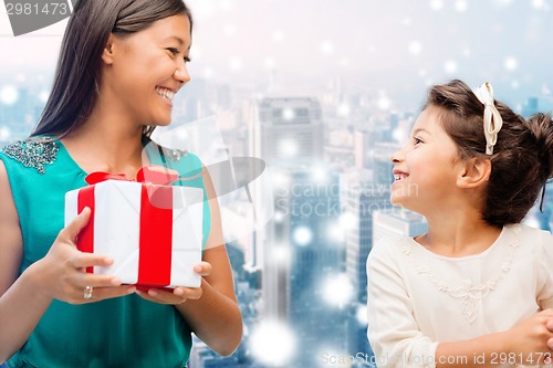 Image of happy mother and little girl with gift box