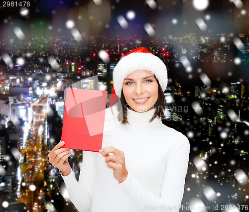 Image of smiling woman in santa hat with greeting card