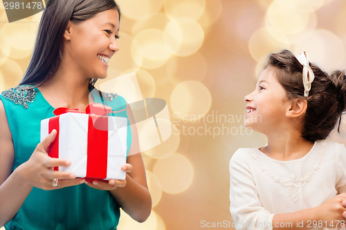 Image of happy mother and little girl with gift box