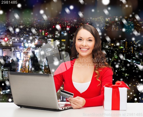 Image of smiling woman with credit card and laptop