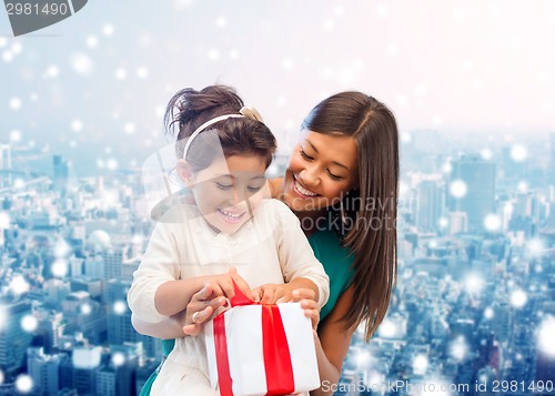 Image of happy mother and little girl with gift box