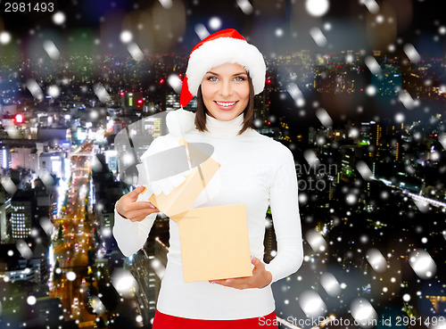 Image of smiling woman in santa helper hat with gift box