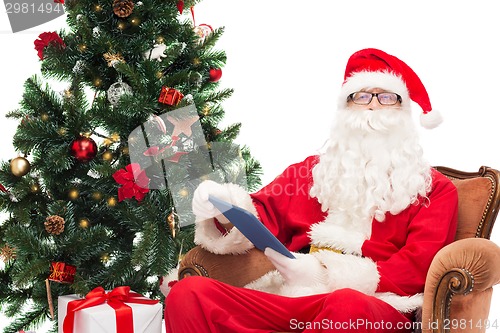 Image of man in costume of santa claus with tablet pc