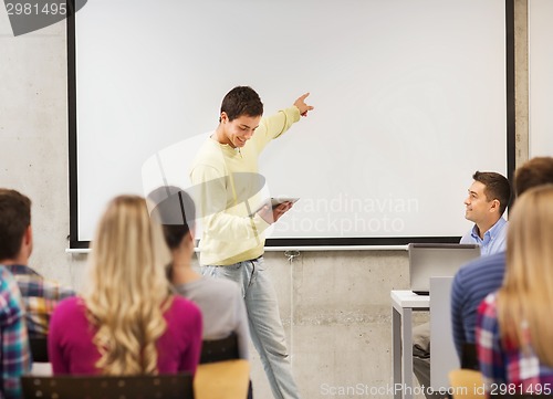 Image of group of smiling students and teacher in classroom