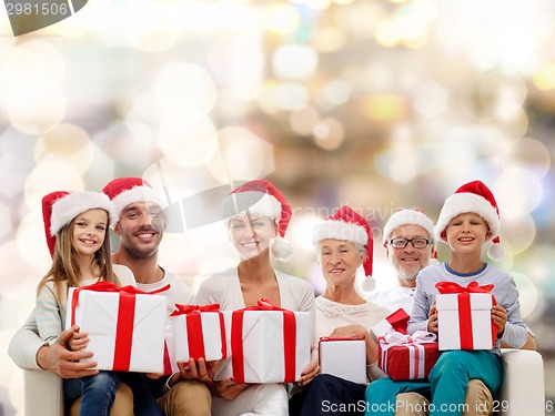 Image of happy family in santa helper hats with gift boxes