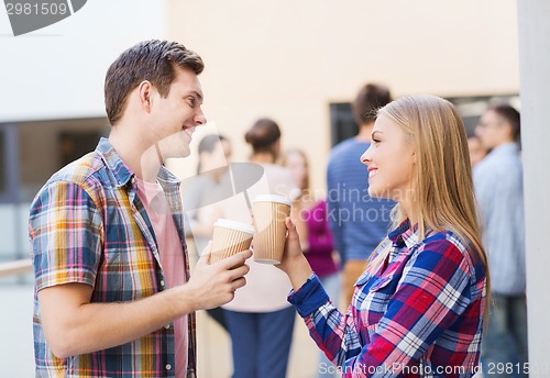 Image of group of smiling students with paper coffee cups