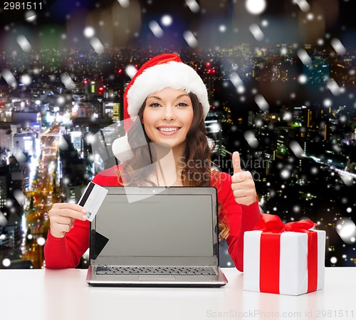 Image of smiling woman with credit card and laptop