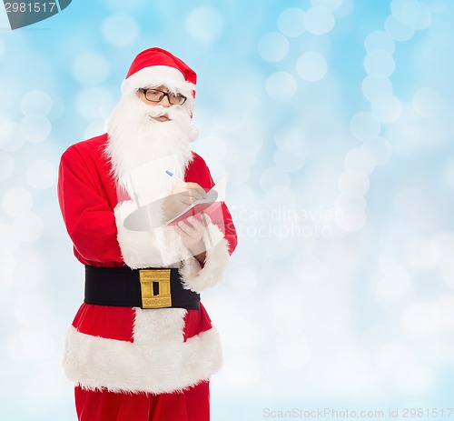 Image of man in costume of santa claus with notepad